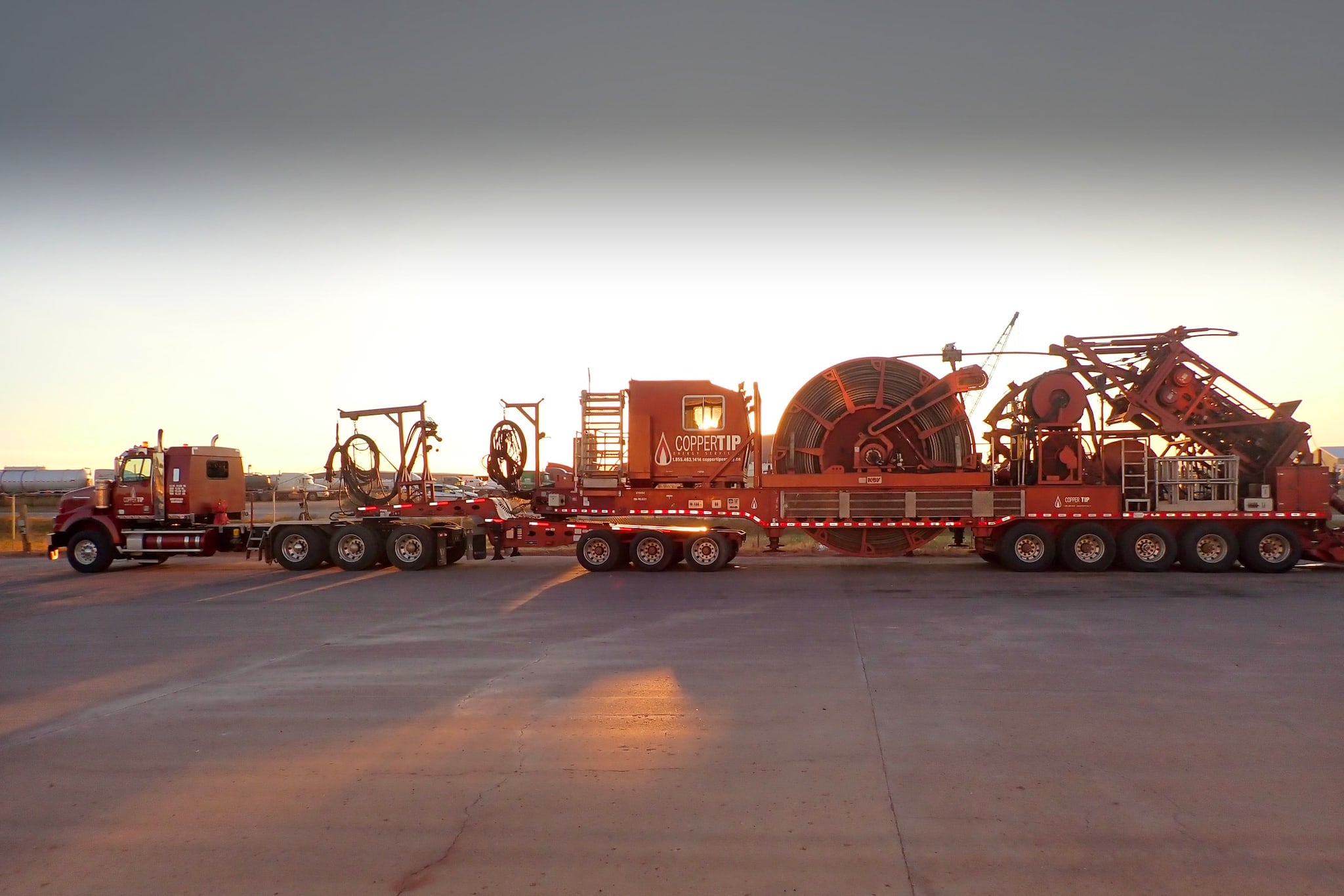 Copper Tip Energy Services coiled tubing unit on its trailer at dawn